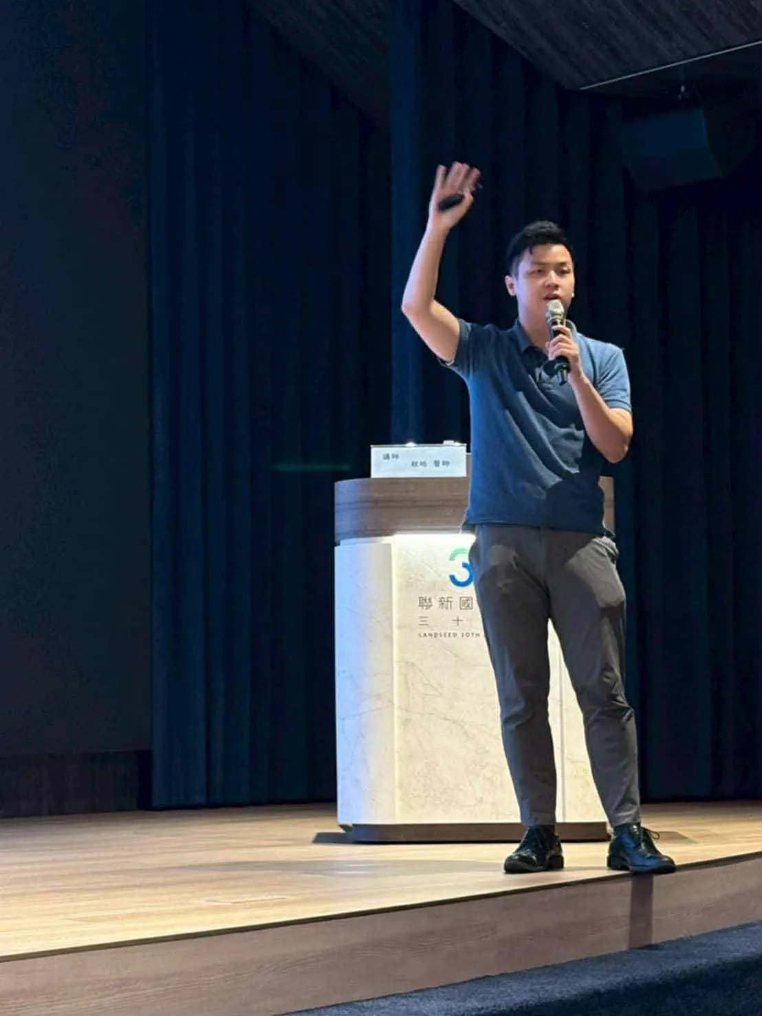 程皓醫師在大型演講廳舞台上對教練群演講